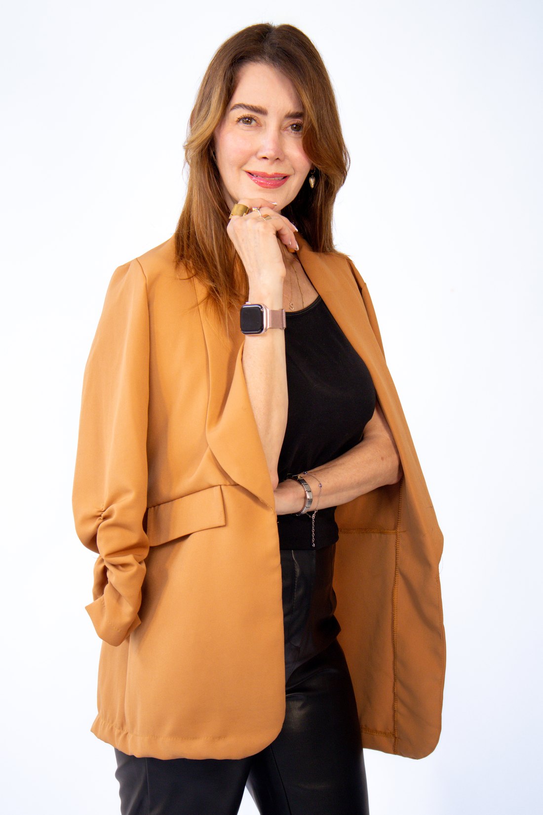 La Dra. Sindri Ramos con saco camel, apoyando la mano en el mentón